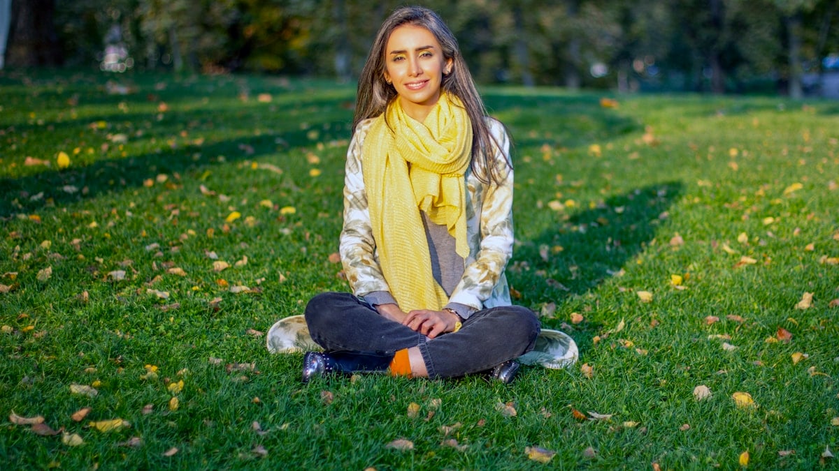 a woman sitting on the grass in a park